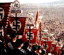 The ballet-like precision of the movement of the uniformed party members, all acting in unison, evoked from the unconscious, the principles of war and violence which the ancients symbolised as Mars. And the prime ritual of the rallies - Hitler clasping to other banners, the 'blood banner' carried in the Munich Putsch of 1923.  